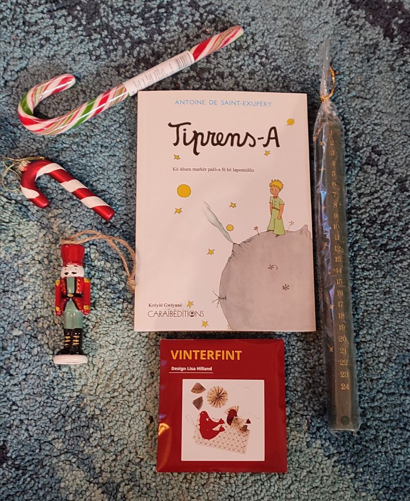 Cadeaux de Noël de mon Santa. Deux décorations de sapin : un en forme de sucre d'orge et un casque noisette, une bougie de Noël numérotée de 1 à 24, un sucre d'orge à manger, des décorations oiseaux à fabriquer soi-même, une édition du Petit Prince en créole Guyanais.