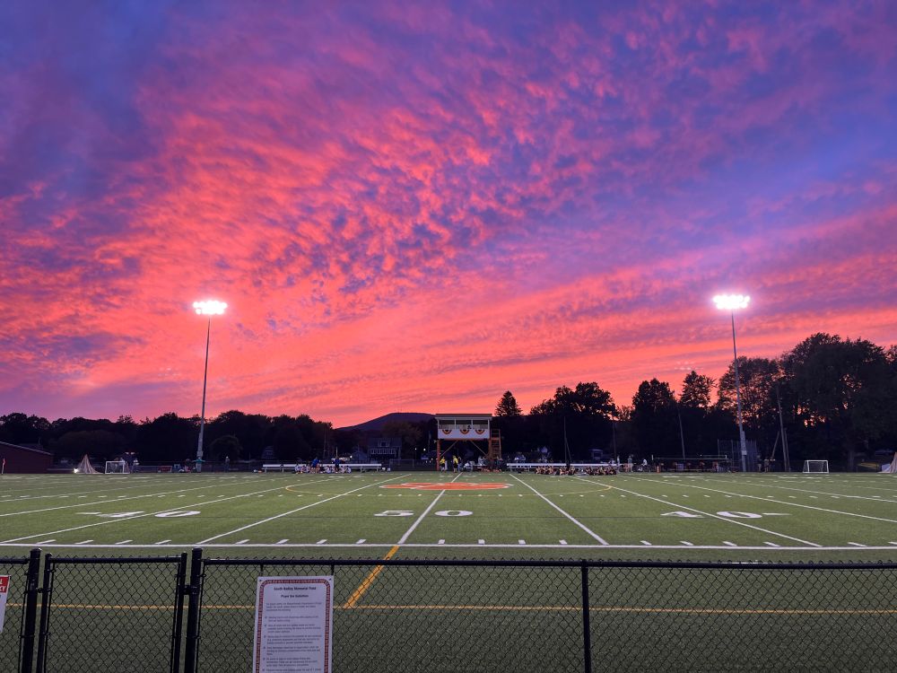 Pink and purple sunset over a field hockey game