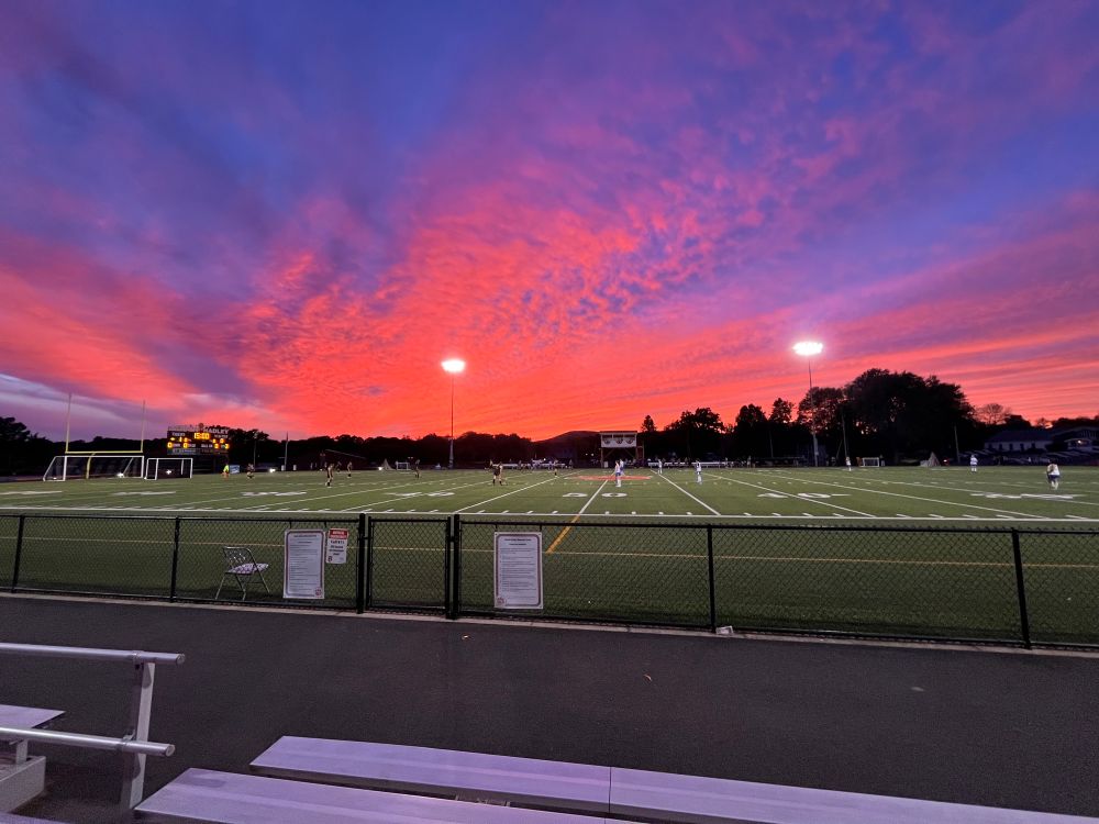 Pink and purple sunset over a field hockey game
