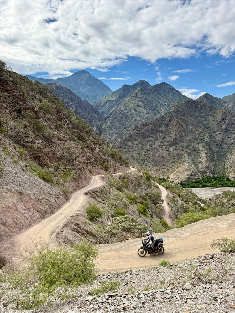 A motorcycle rider in a desert canyon