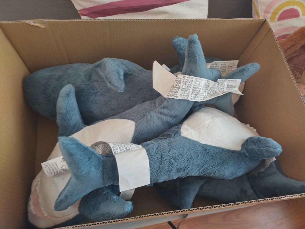 a cardboard box with five ikea blahajs in it seriously what am I gonna do with five blahajs