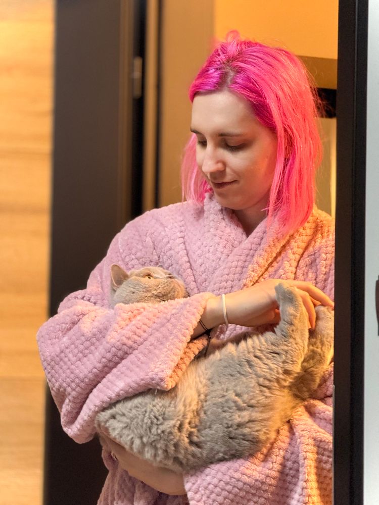 Kanba holding her cat, looking peaceful and happy