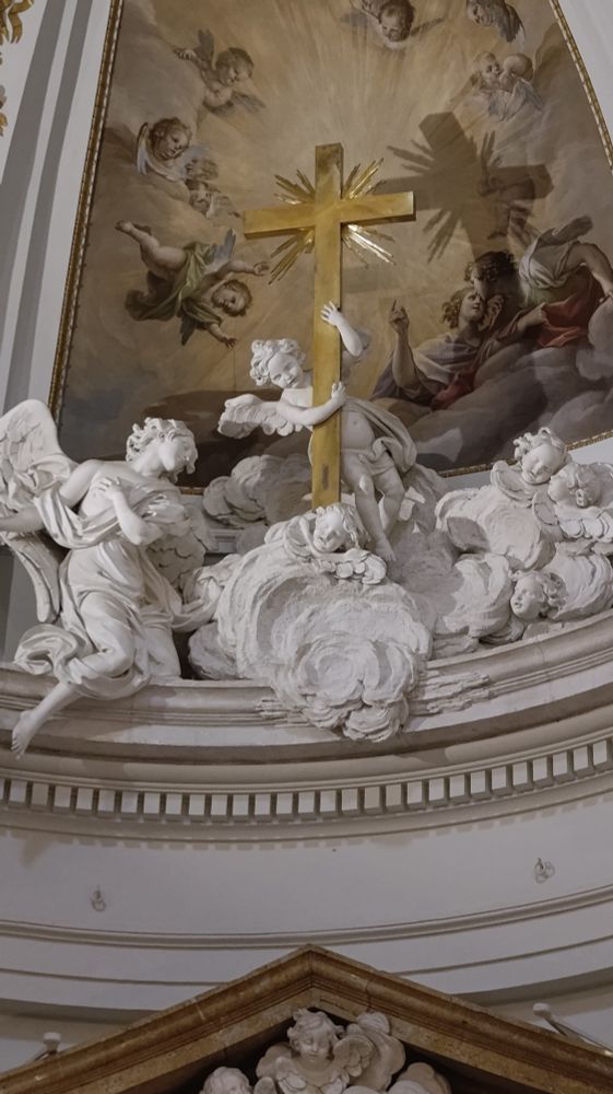 Esculturas de ángeles en mármol blanco en la repisa de una capilla