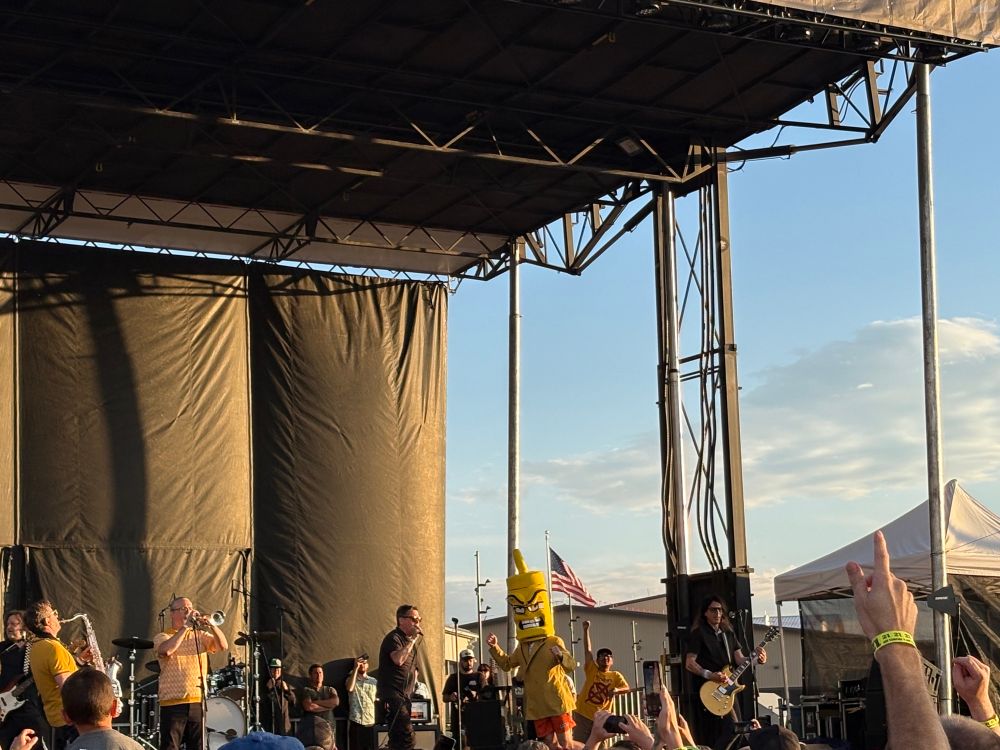 The ska band Mustard Plug playing on stage with someone dressed as a mustard bottle