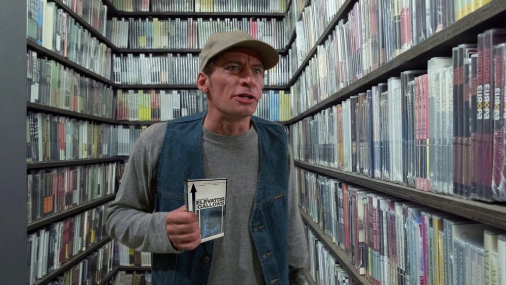 ernest p. worrell standing in the criterion closet holding a dvd copy of louis Malle's elevator to the gallows