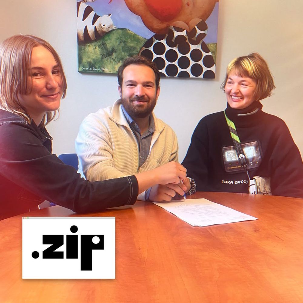 .zip members Roos (woman), Remco (man) and Cyanne (genderfluid) sign the contract to the association while all holding one pen together