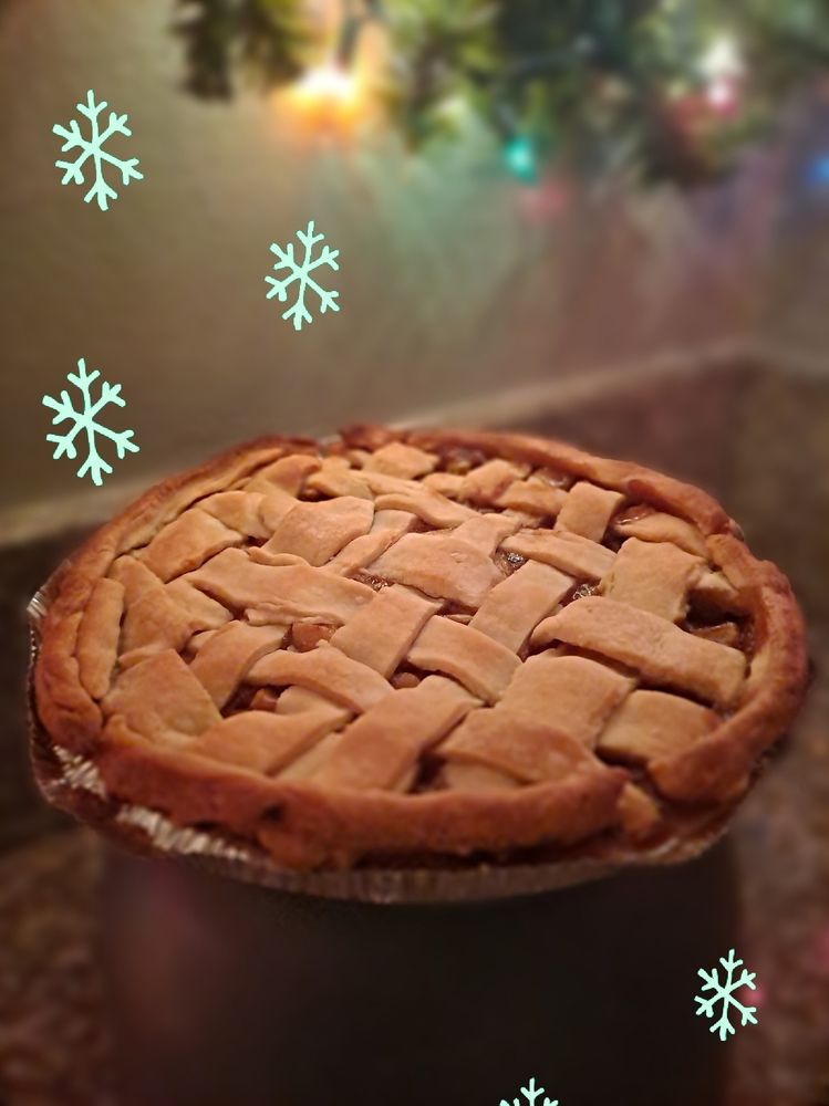 Apple pie displayed on the counter. Stock image snowflakes are around the pie