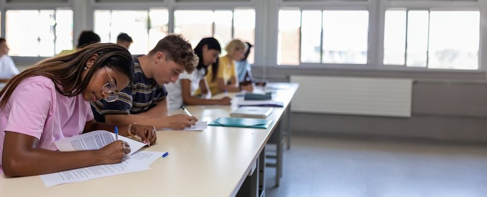 students working at a long desk in classroom