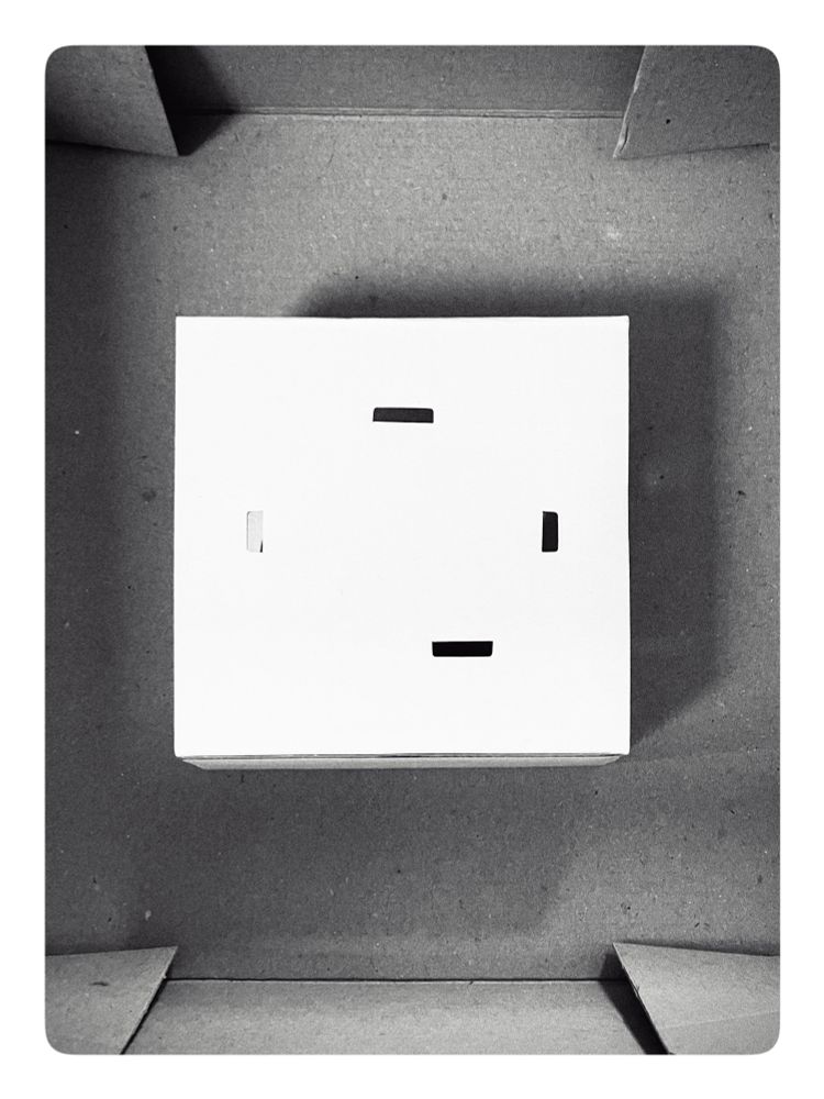 A black and white Foto of cardbord delivery boxes, stacked to create an 
abstract image. 
