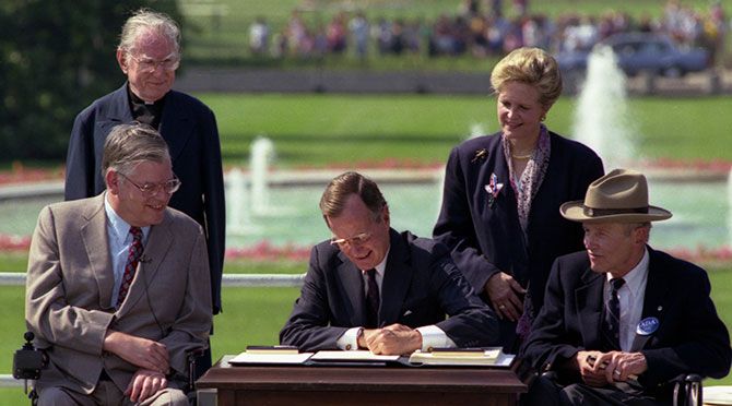 President George H. W. Bush signs the Americans with Disabilities Act into law.