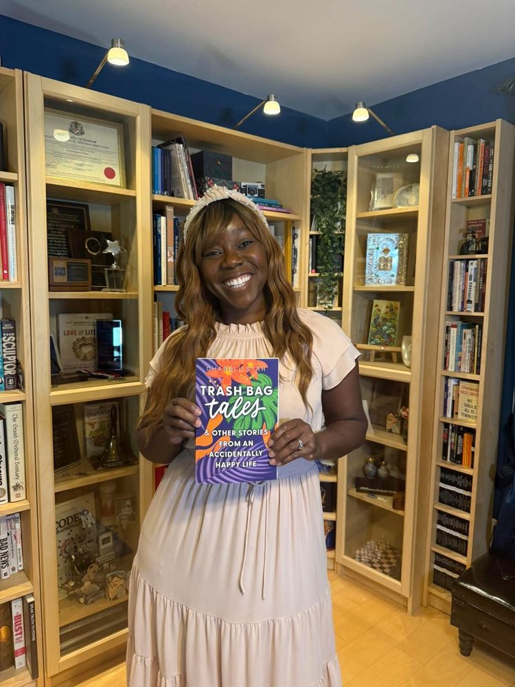 Charell Star holding her new memoir: Trash Bag Tales & Other Stories of an Accidentally Happy Life. 