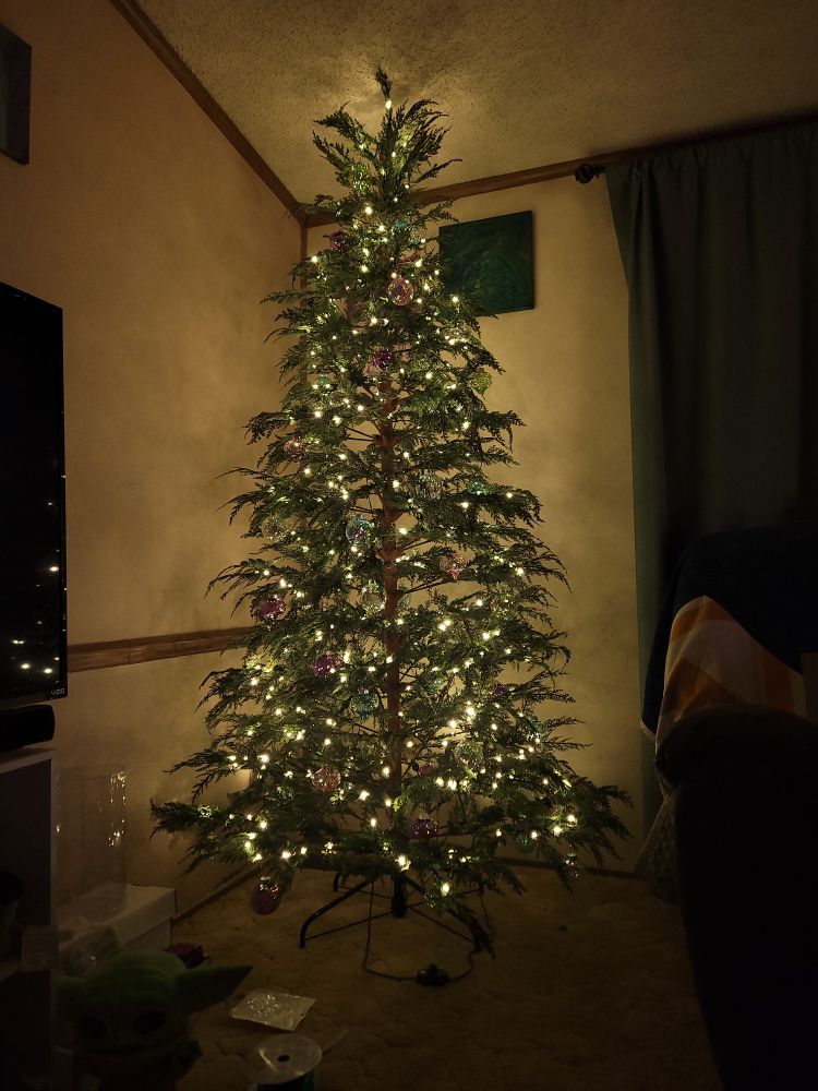Christmas tree decorated with soft lights and translucent multicolored baubles