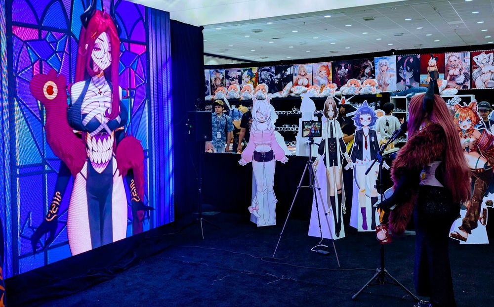 Left side is a large screen with Giwi projected onto it and on the right is Giwi cosplayer (keybeau) talking into a mic chating with real Giwi