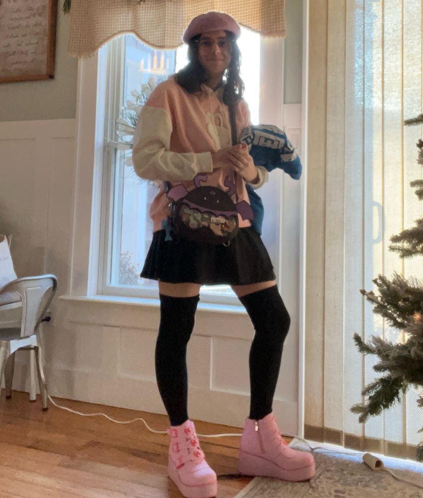 me wearing pink platform boots, black thigh highs, black skirt, pink/white bunny hoodie with a soft white bunny in middle. i’m carrying my blue jacket and my purse is on my side