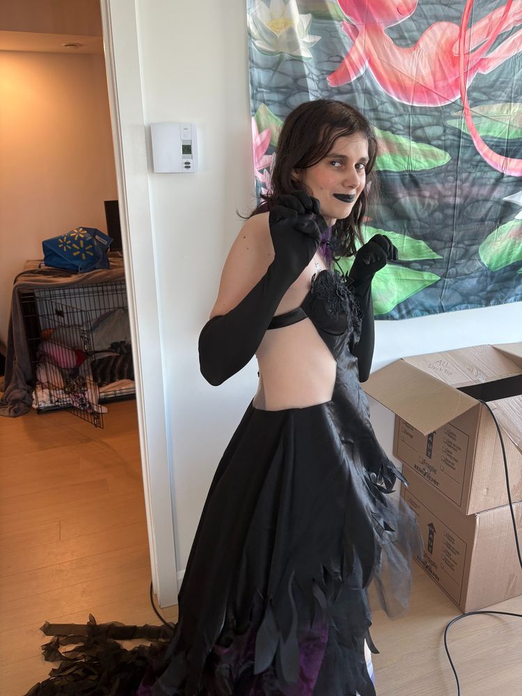 Me in devil homura cosplay standing against the wall pawing with my hands?