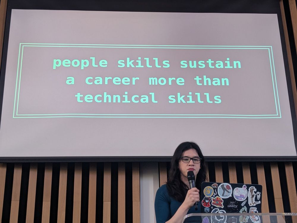 Woman speaker in front of a slide saying people skills sustain a career more than technical skills