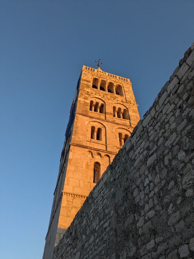 Medieval tower in the evening sun, against clear blue sky