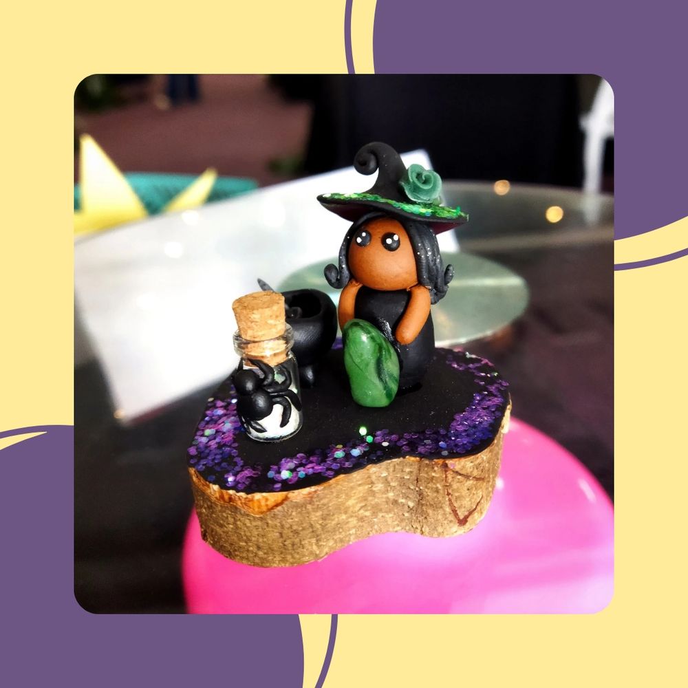 Miniature witch holding a green crystal, made out of polymer clay.  