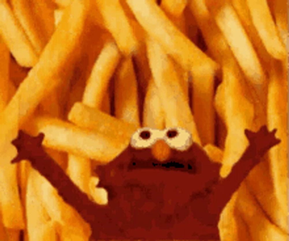 elmo from sesame street is standing in front of a pile of french fries