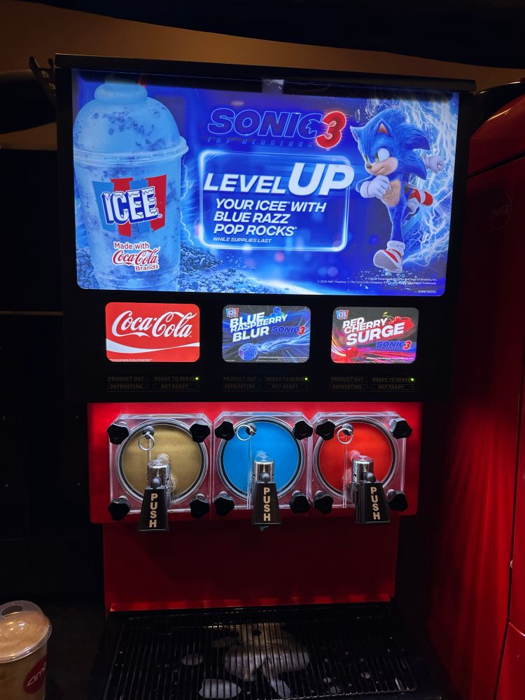 Icee machine advertising Sonic 3 and featuring three flavors: Blue Blueberry Rush, Red Cherry Surge, and Coca-Cola.