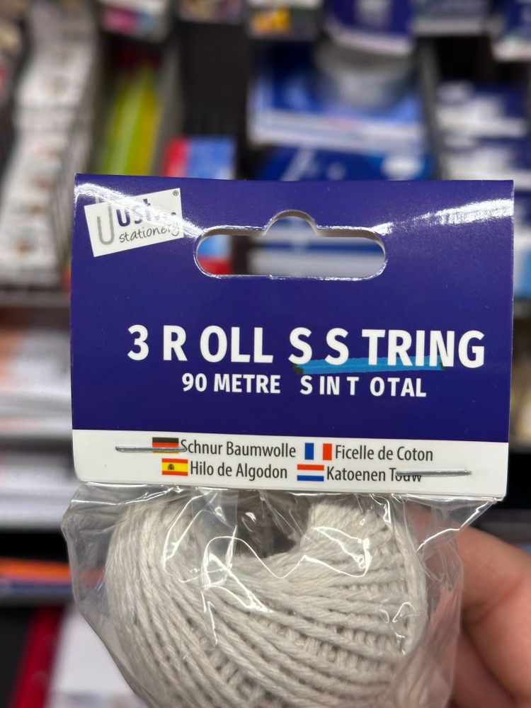 A package of rolls of string, labeled ”3 R OLL S S TRING 90 METRE SINT OTAL”