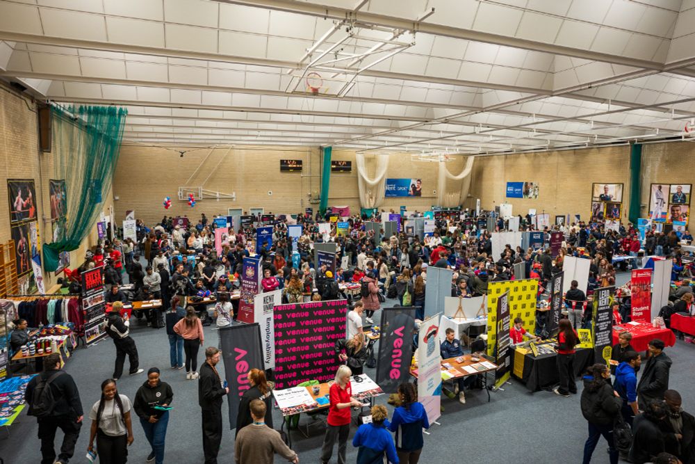 A packed sports hall full of students with stalls covering a wide range of sports, societies and opportunities