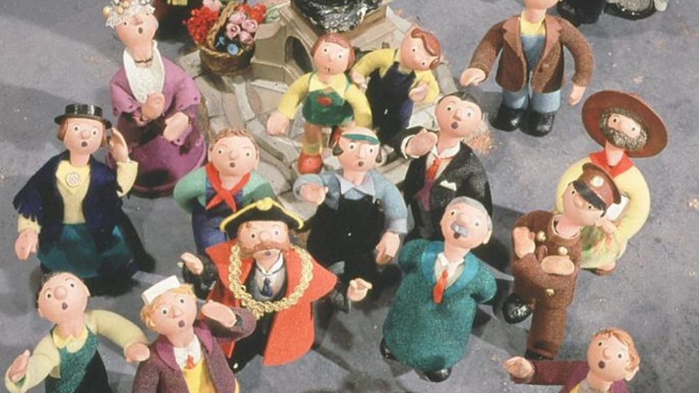 Photo of the cast of Trumpton take from above (as if by a drone) with them all looking up at the camera.