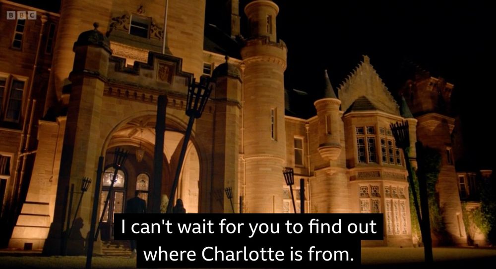 A castle at night with subtitles that read: “I can’t wait for you to find out where Charlotte is from.”