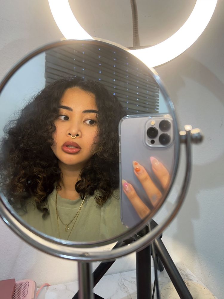 picture of person with curly hair parted down the middle 