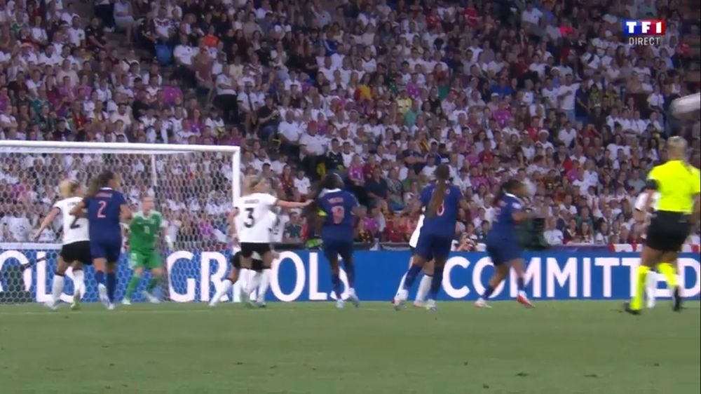 Screenshot from France-Germany soccer match. It shows a German player wearing a white jersey with number 3 grabbing the braids of a French player wearing a blue jersey with number 9. They are inside the box in front of the German goal.
