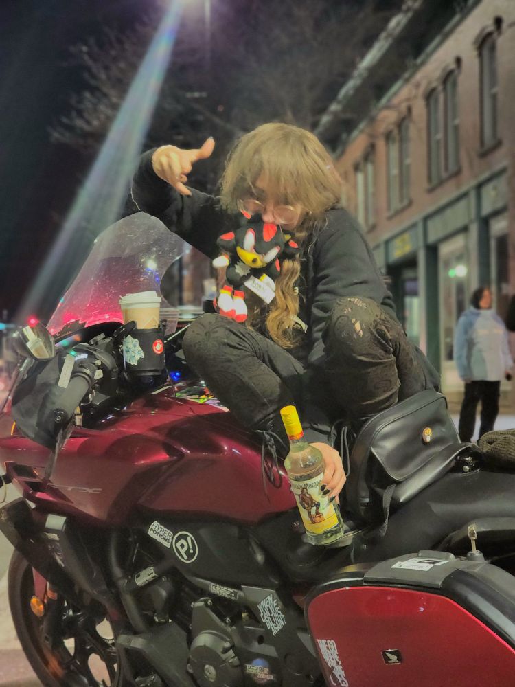 some unknown dumbass idiot (me) balancing on her honda ctx700 dct motorcycle holding a bottle of captain morgan in one hand and shadow the hedgehog in her mouth like a baby bird. i think this is the day i put on all the stickers you can see from flcl + tom delonge + owl city + httyd + sonic adventure 2 and hyper potions and pretty much this just what boston is like