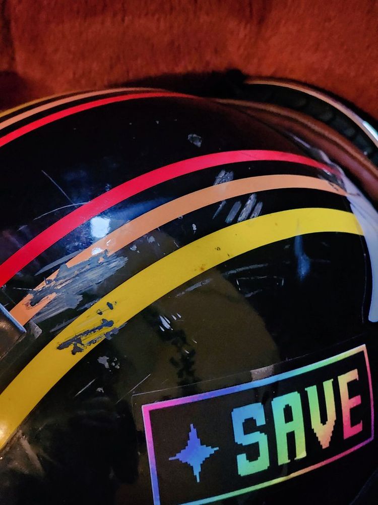 "But it refused." and "SAVE" stickers from Undertale on a motorcycle helmet after a crash, with impact marks directly between the two. Also Ralsei Deltarune was there, thanks Ralsei, flop with me again anytime