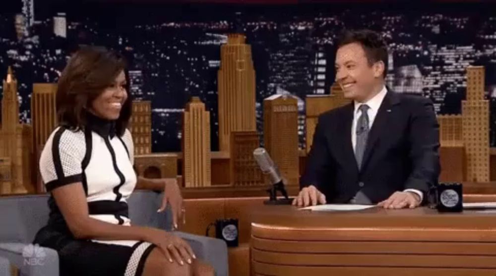 a man in a suit and tie is sitting next to a woman in a dress .