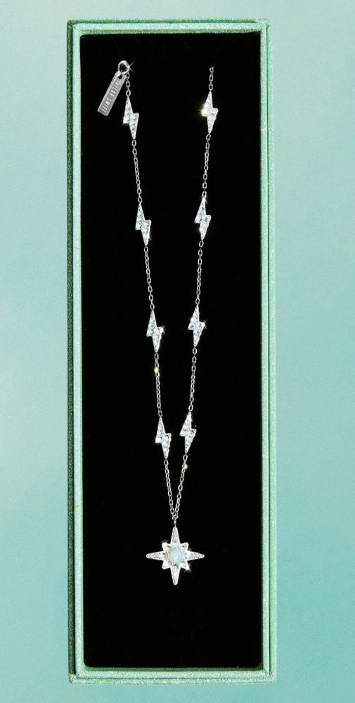 photo of a necklace released by Taylor Swift in promotion of the latest album depicting an 8 pointed diamond star pendant hanging from a chain consisting of 8 crystal encrusted SS lightning bolts arranged in 4 matching pairs, with each bolt connected by a silver chain of 14 individual links