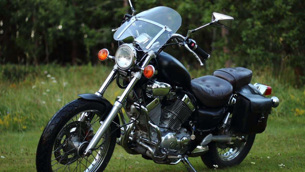 A photo of a Yamaha XV535 Virago, parked on grass.