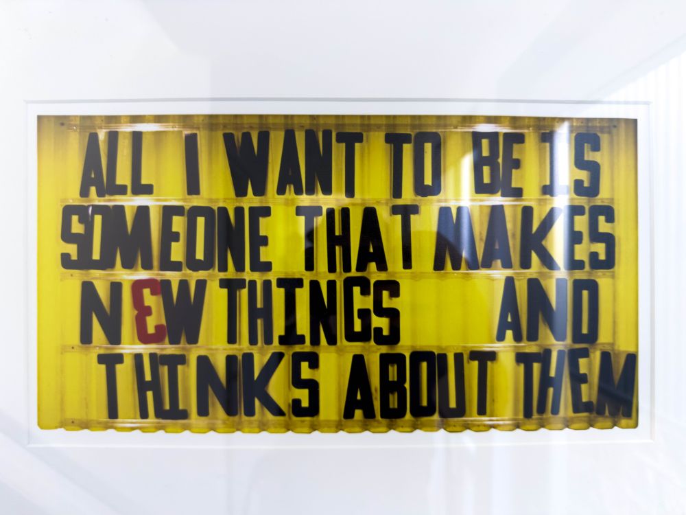 A sign that reads "All I want is to be someone that makes new things and thinks about them."