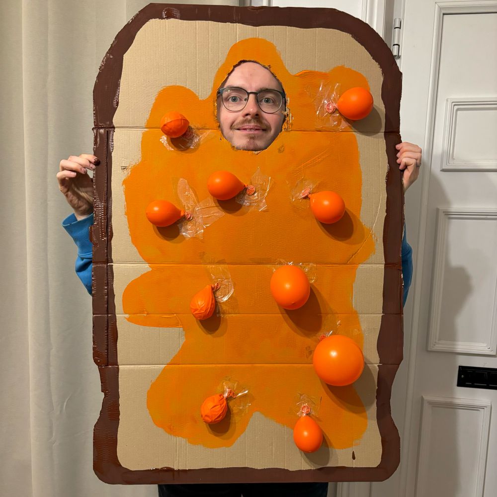 Arthur in his beans on toast outfit, made from a sheet of cardboard painted to look like toast and orange balloons as beans