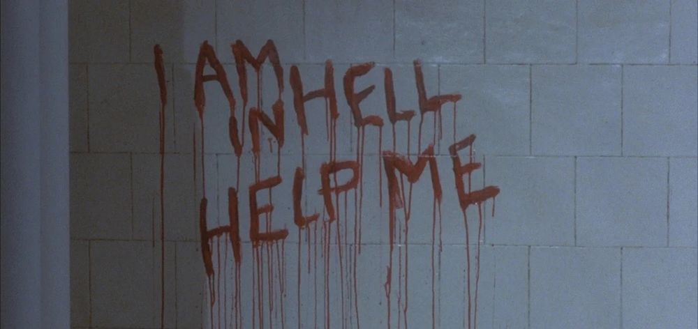 The words "I am in hell help me" written in blood on white tile wall, from the movie hellraiser 2