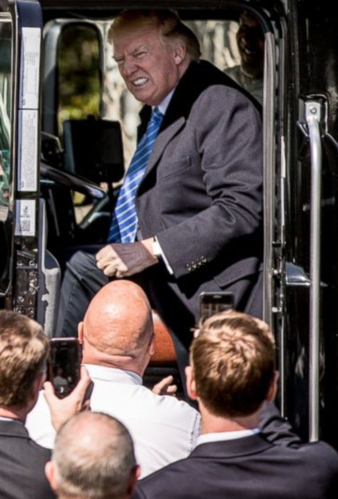 Donald sitting in the driver's seat of a truck, grimacing 