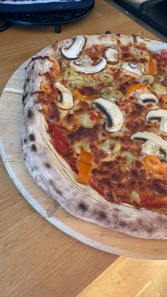 Sourdough pizza on a board ready to be sliced