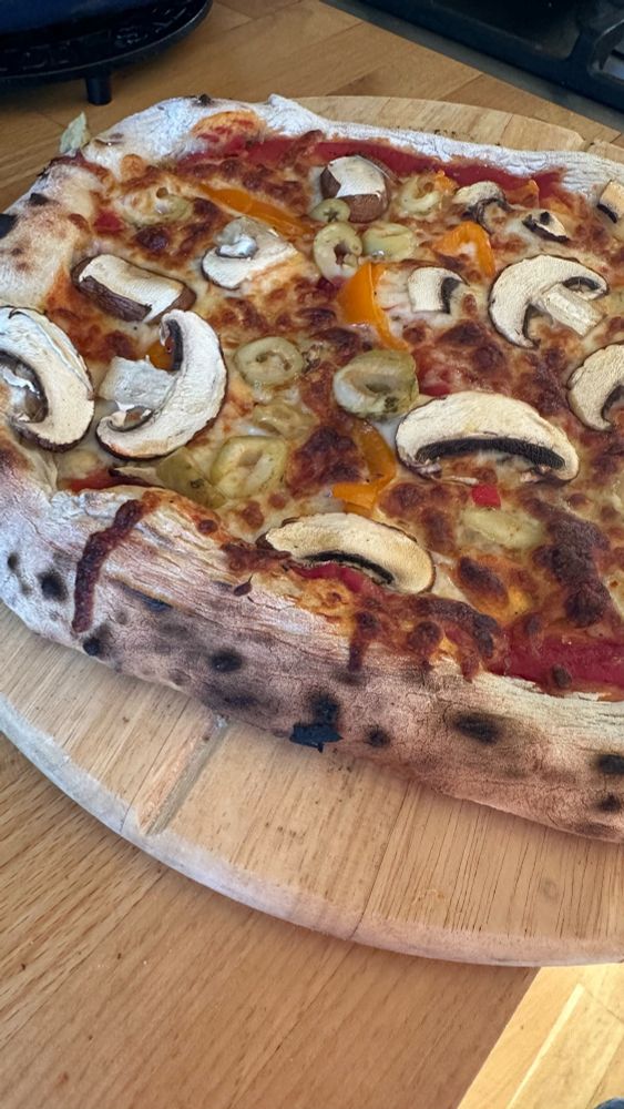 Sourdough pizza on a board ready to be sliced