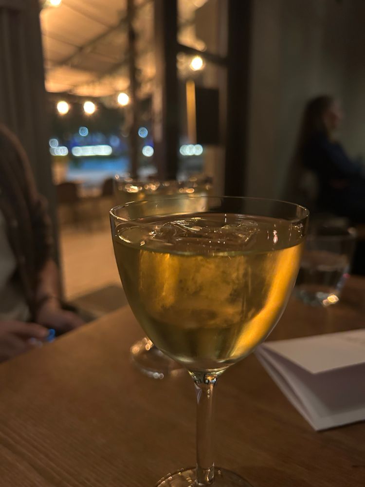 En ljusgul genomskinlig cocktail på ett träbord