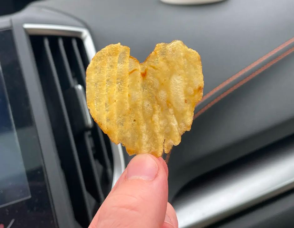 A ruffled, heart shaped kettle chip is held tenderly in the hand of my youngest baby while we enjoyed lunch together after their ceramics class 