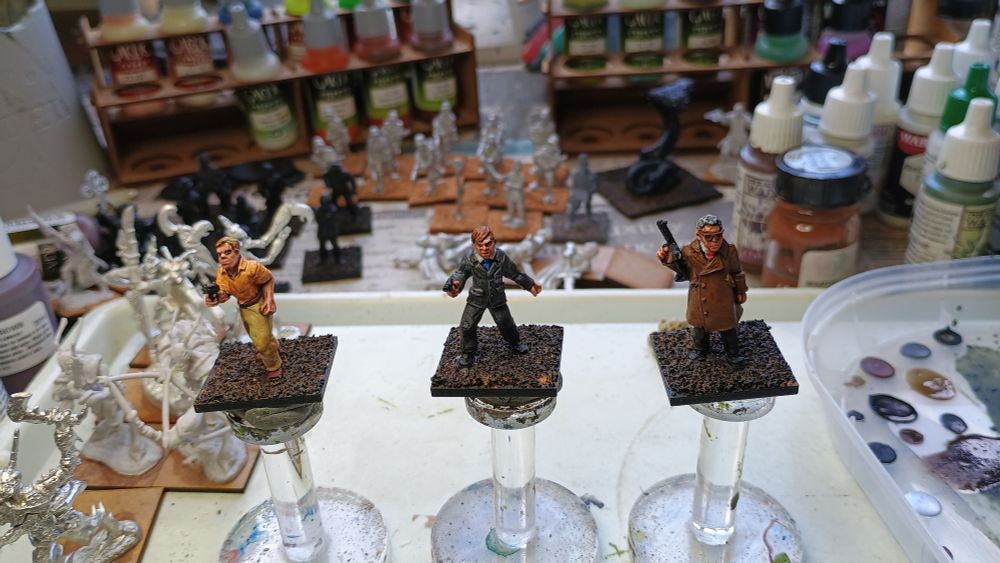 3 28mm miniature figures from the Kiss Kiss Bang Bang range that are part way through being painted.