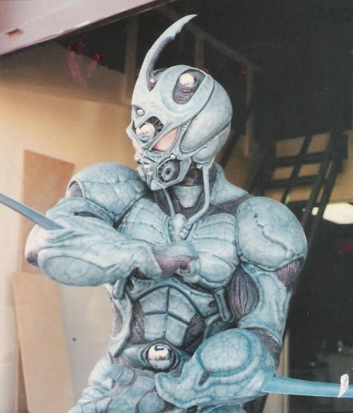 A photo of the guyver suit from the 1992 film. The suit is a washed green and red underneath and looks like a bug 
