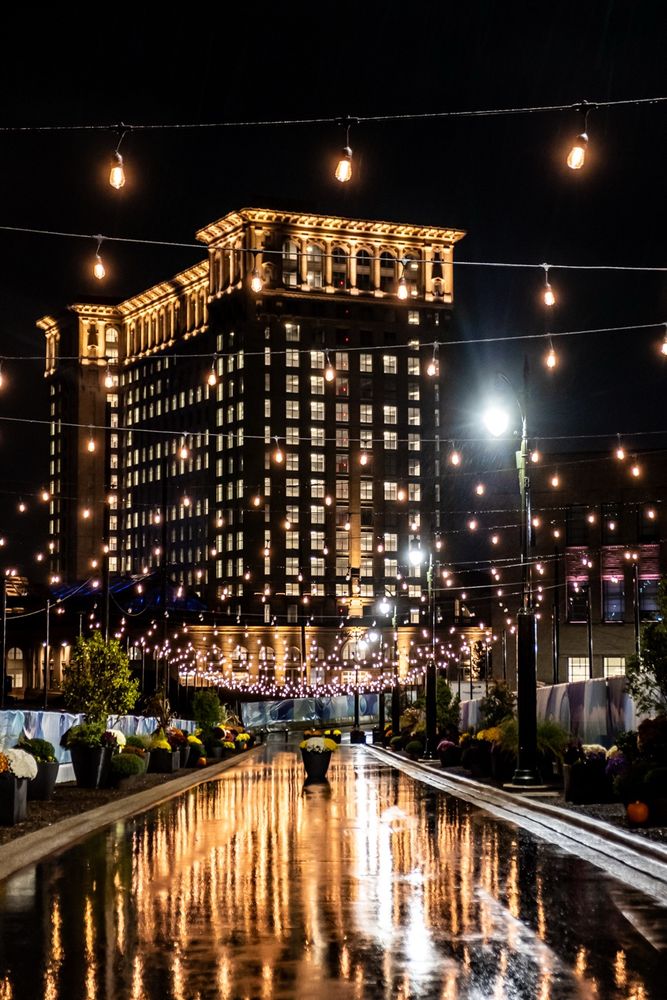 Color photograph of Michigan Central lit up on a rainy night in Detroit’s Corktown. The former train station was restored to its glory by Ford Motor Co.