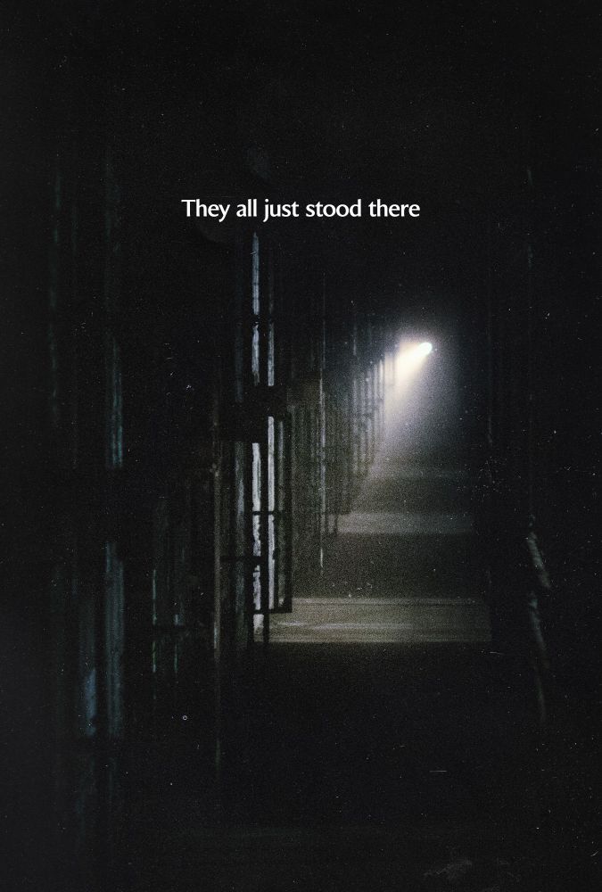 a dark image of inside a prison at night with the text "They all just stood there"