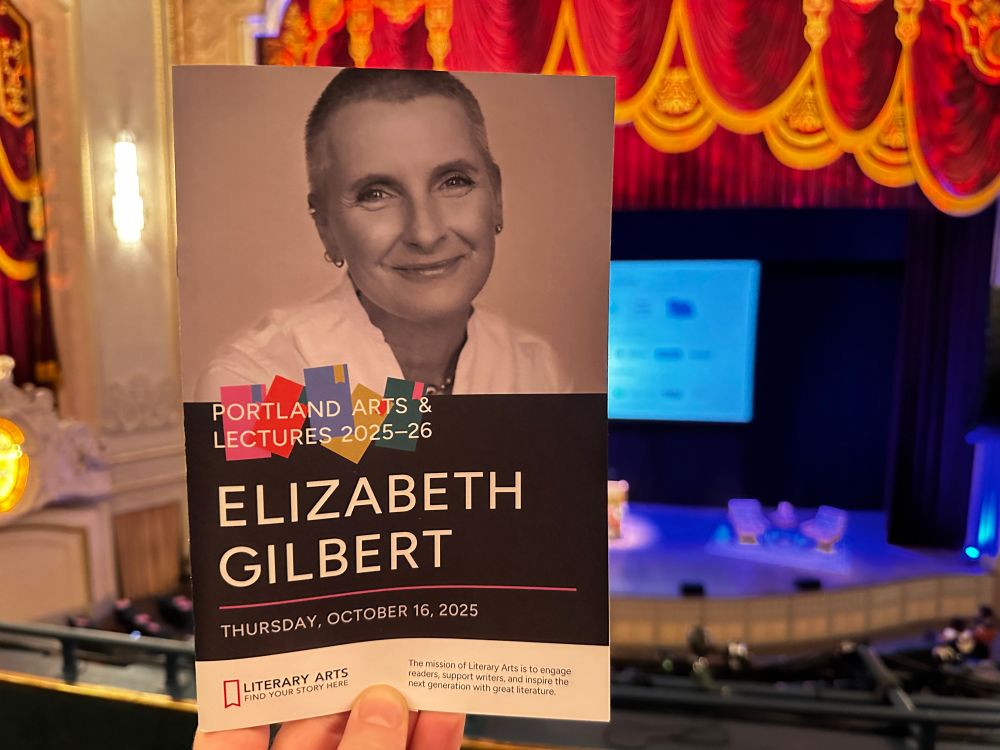 Event program for Literary Arts lecture with Elizabeth Gilbert with the stage of  Arlene Schnitzer Concert Hall in the back. 