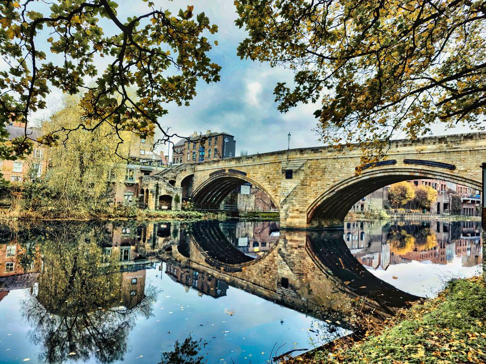 Framwellgate Bridge in Durham, UK. Two stone catches reflected in a still river