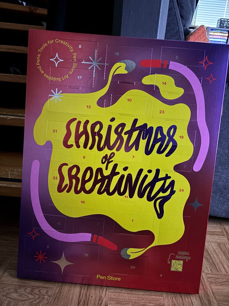 Pen Storen iso metallinhohtoinen, pinkki joulukalenteri jossa iso keltainen läiskä ja teksti: Christmas of creativity.